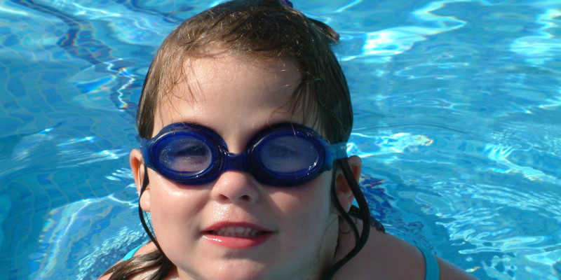 portrait girl wearing swimming goggles pool